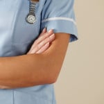 UK nurse standing with arms folded